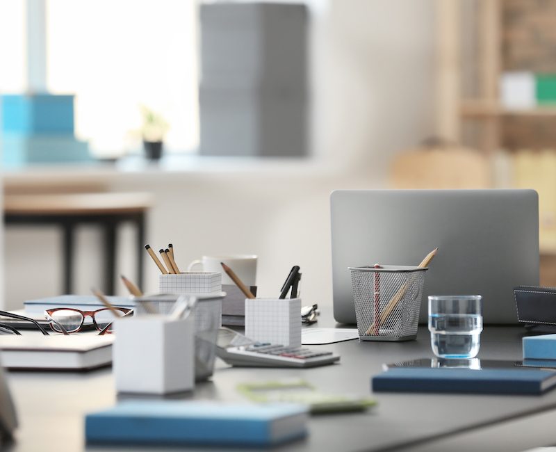 Table with modern laptop and stationery in office
