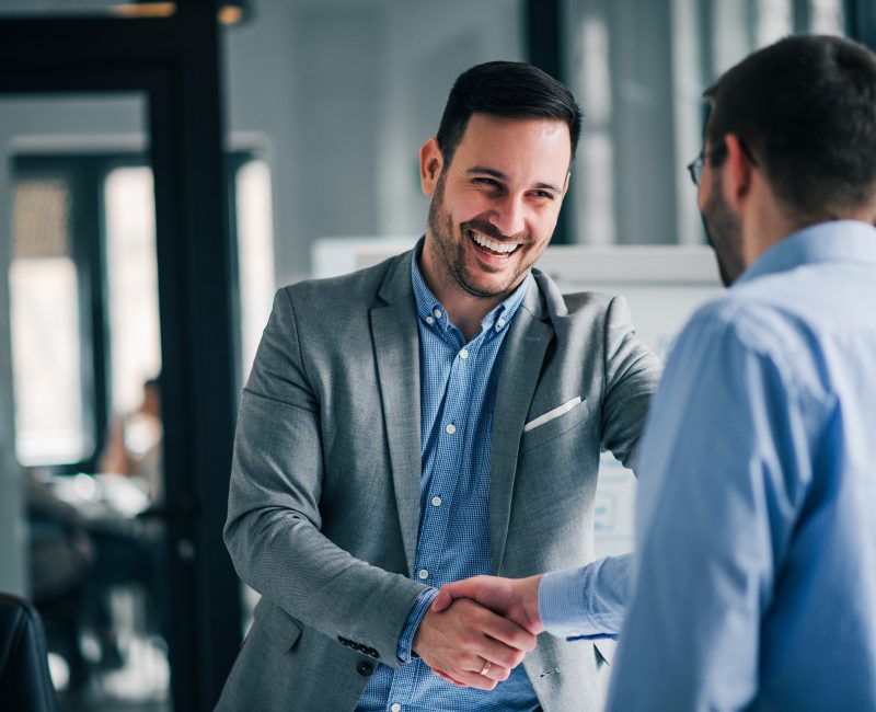 Portrait of cheerful young manager handshake with new employee.